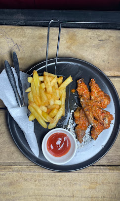 Hot chicken wings with fries and ketchup on a metal plate